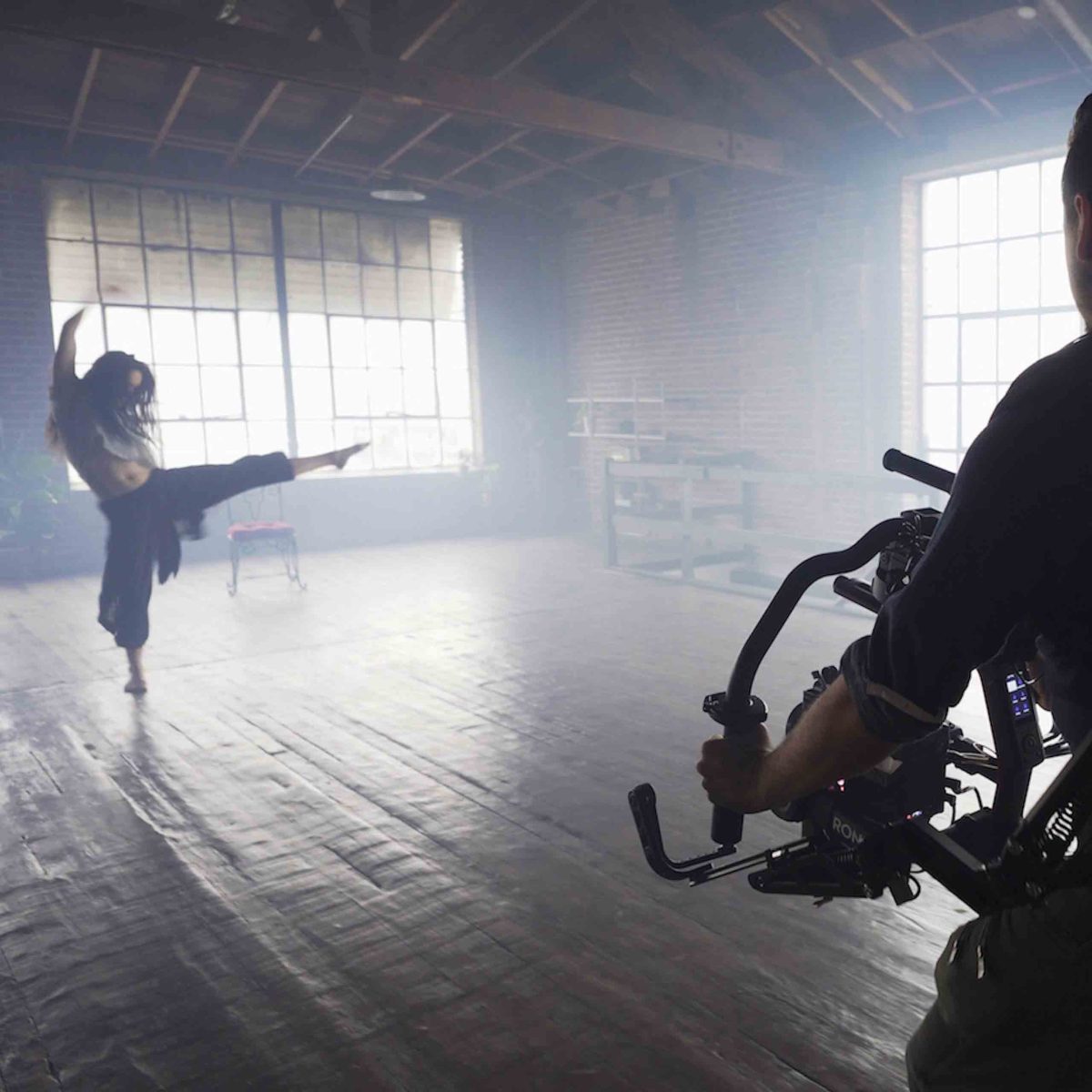 Eine Tänzerin trägt Markenprodukte und wird von einem Kameramann gefilmt.